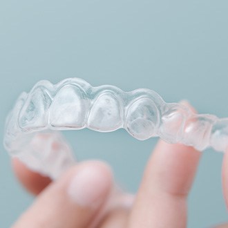 Closeup of patient holding clear aligner