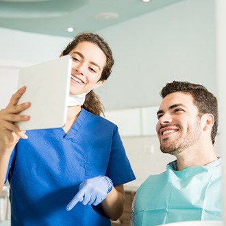 Dentist showing patient image on tablet